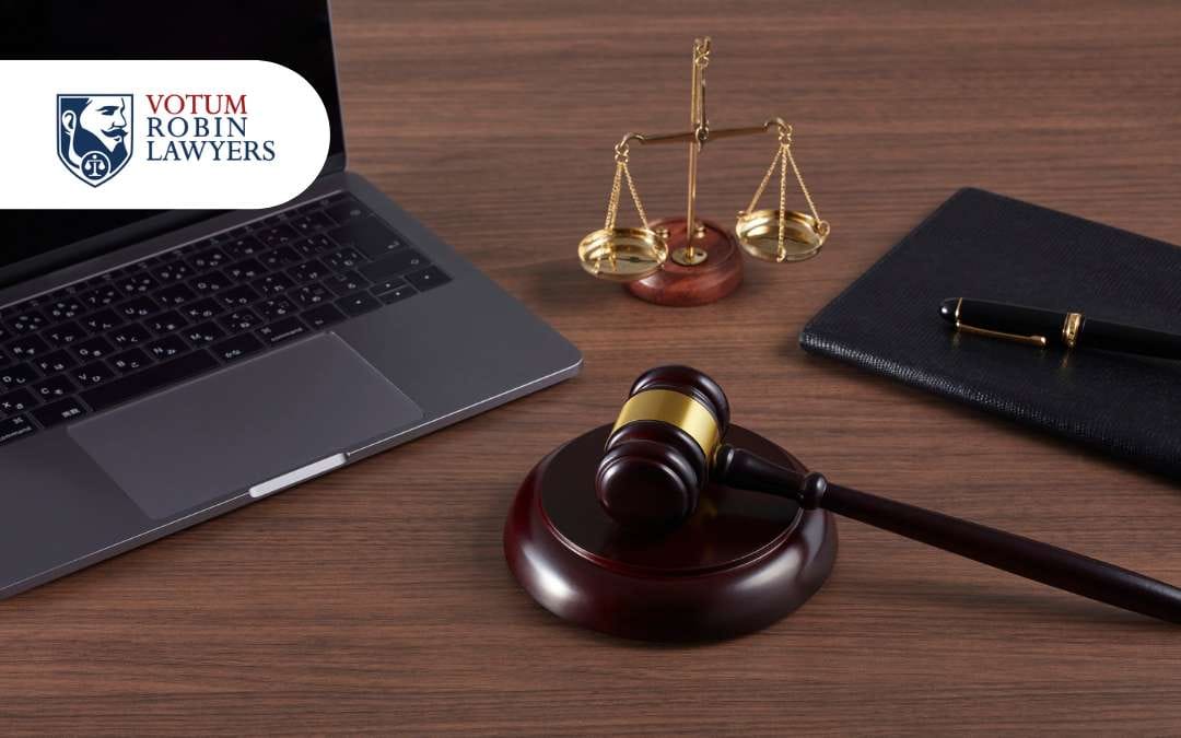 Laptop, złota waga, młotek sędziowski, dokumenty