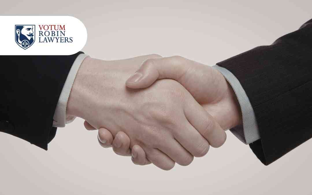 Dwie osoby podają sobie ręce na znak zawarcia ugody frankowej z bankiem w 2026 roku.