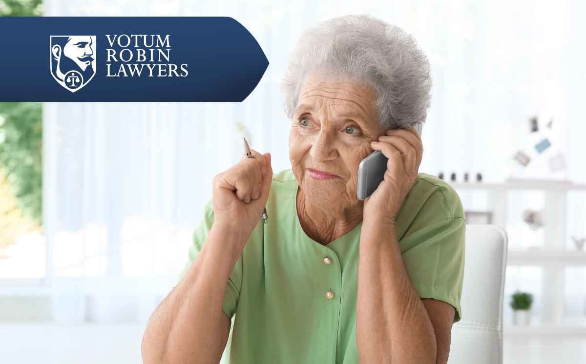 Two lawyers in suits review documents on a desk with a gavel and scales of justice; law firm logo in the corner.