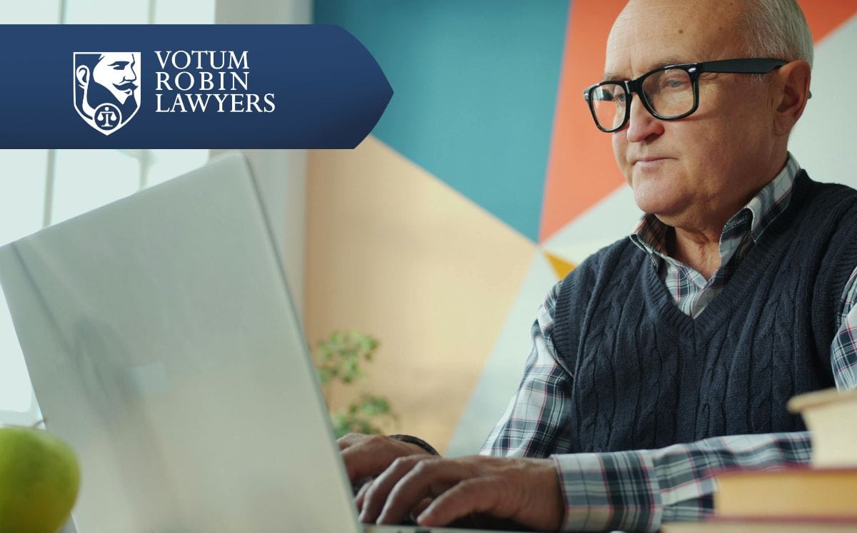 Two lawyers in suits review documents on a desk with a gavel and scales of justice; law firm logo in the corner.