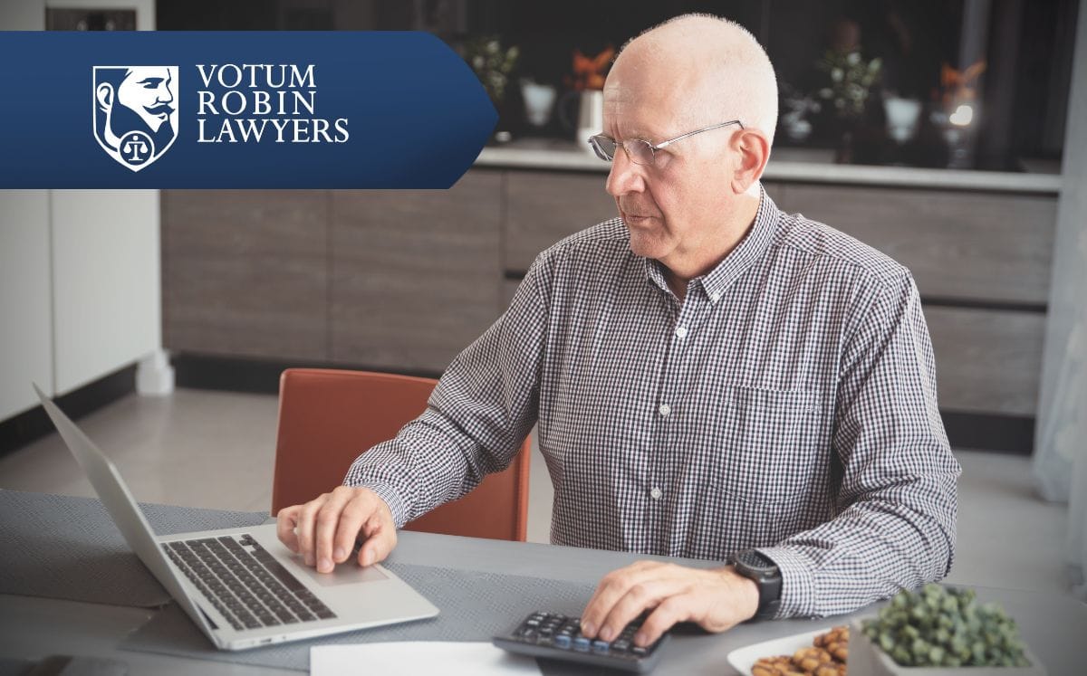 Two lawyers in suits review documents on a desk with a gavel and scales of justice; law firm logo in the corner.